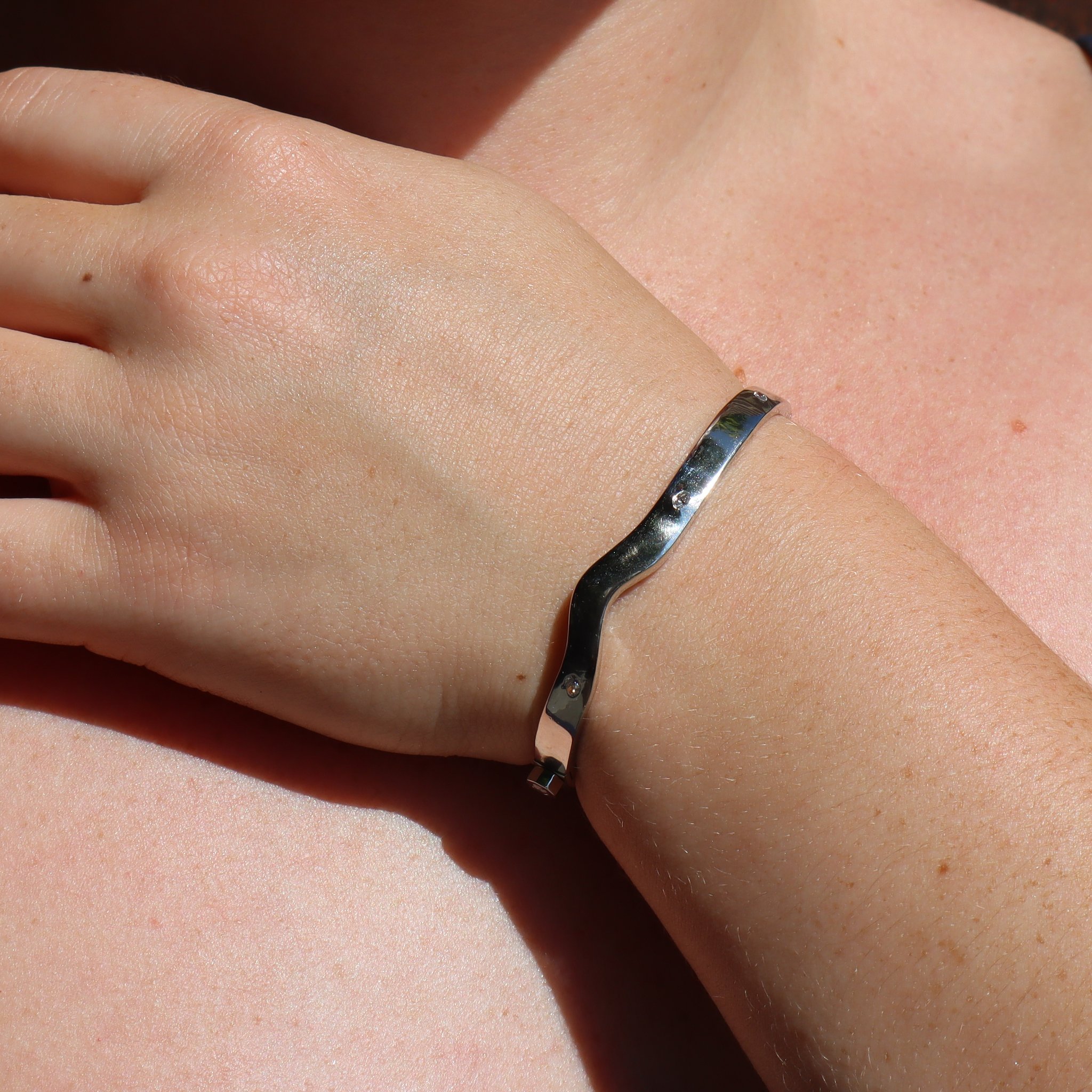 Raw Platinum Diamond Bracelet with Pink Diamond Hex Nut worn outdoors